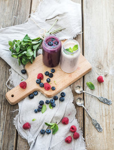 Fresh healthy smoothie with blueberries raspberries in glass jars and mint