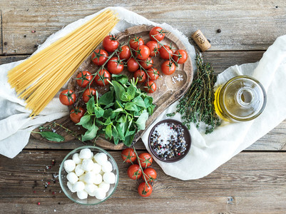 Ingredients for cooking pasta  Spaghetti  basil  cherry tomatoes  mozarella  olive oil