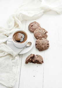 Chocolate cookies with almond and cranberries  cup of coffee  white wooden backdrop