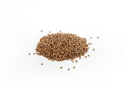 Brown buckwheat groats on white background