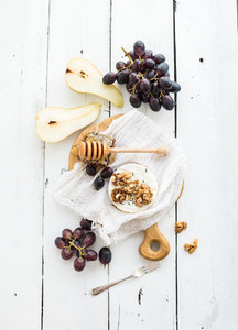 Camembert cheese with grape  walnuts  pear and honey on vintage metal plate over white rustic wood backdrop
