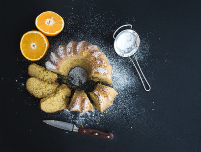 Moist orange bundt yoghurt cake with sugar powder on top  dark grunge background
