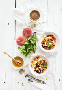 Healthy breakfast  Bowl of oat granola with yogurt  fresh fruit  mint and honey  Coffee  vintage silverware  Top view