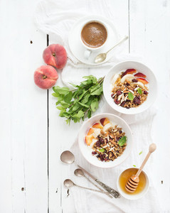 Healthy breakfast  Bowl of oat granola with yogurt  fresh fruit  mint and honey  Coffee  vintage silverware  Top view
