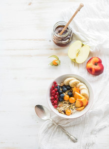 Healthy breakfast  Bowl of oat granola with yogurt  fresh berries  fruit and honey  Top view