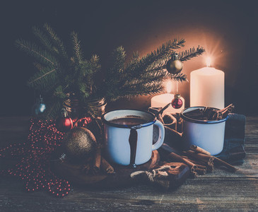 Christmas food and decorations set  Fur tree branches  mug of hot chocolate  colorful glass balls  burning candles  cinnamon sticks  dark background