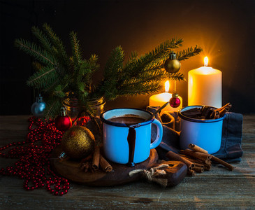 Christmas food and decorations set  Fur tree branches  mug of hot chocolate  colorful glass balls  burning candles  cinnamon sticks  dark background