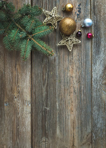 Christmas or New Year rustic wooden background with toy decorations  candy cane and fur tree branch  top view