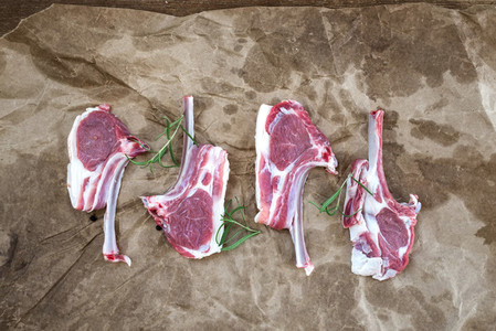 Raw lamb chops  Rack of Lamb with rosemary and spices over oily craft paper background