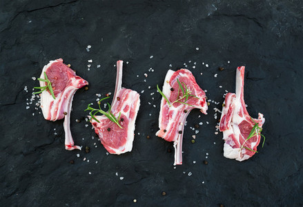 Rack of Lamb with rosemary and spices over dark slate stone background