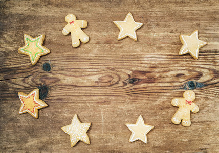 Christmas homemade gingerbread cookies of man and stars over rustic wooden background  top view