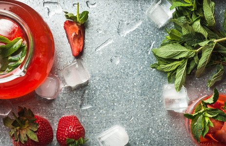 Homemade strawberry lemonade with mint ice and fresh berries over metal tray background top view copy space