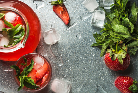 Homemade strawberry lemonade with mint  ice and fresh berries over metal tray background  top view  copy space