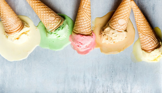 Colorful ice cream cones of different flavors  Melting scoops  Top view   steel metal background