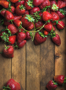 Strawberries over natural wooden background