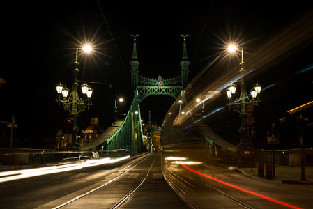 Night view of tram and cars crossing Liberty Bridge in Budapest  Hungary