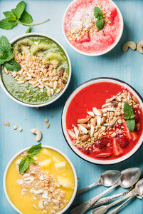 Healthy summer breakfast concept  Colorful fruit smoothie bowls on turquoise blue background