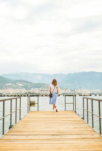 Young woman walking along pier