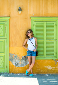 Young blond woman in typical Greek town with colorful buildings on Kastelorizo Island  Greece