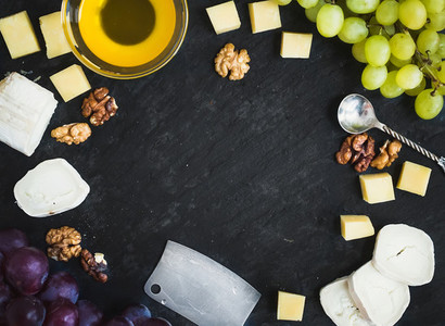 Cheese selection with fresh grapes  walnuts and honey on a dark