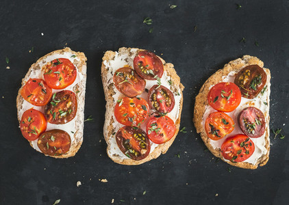 Ricotta and cherry tomato sandwiches with fresh thyme over a dar