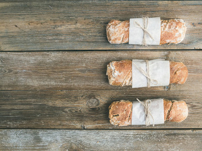 Freshly baked rustic  village bread baguette set on rough wood