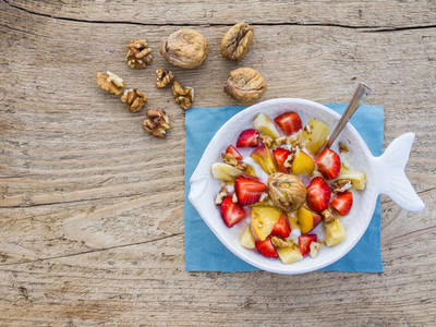 A bawl of fruit  walnuts and yogurt