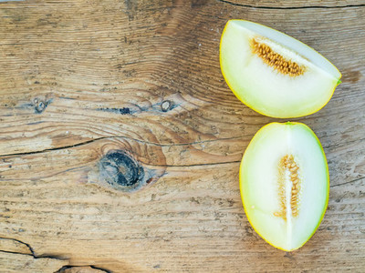 Two pieces of melon on a wooden background