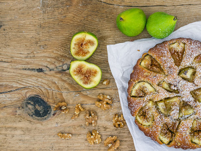 Fig pie with walnuts on a wooden desk