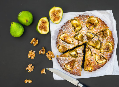 Fig pie with fresh figs and walnuts on black