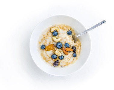 Oat porridge with fresh blueberry  nuts and honey in a white cer