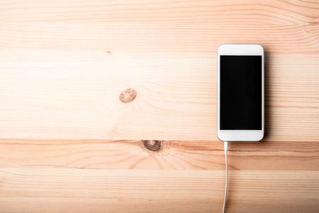 Blank smart phone on wood grain