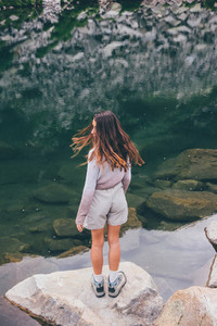 Girl looking at a mountain lake