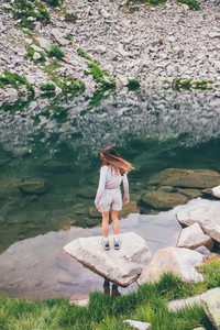 Girl looking at a mountain lake