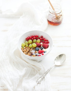 Healthy breakfast Bowl of oat granola with yogurt fresh berries and honey