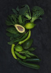 Raw green vegetables set  Broccoli  avocado  pepper  spinach  zuccini and  lime on  dark stone background