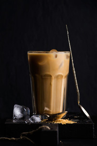 Iced coffee with milk in a tall glass  black background
