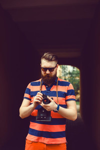 Beard man using film camera