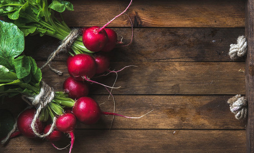 Fresh radish banches on wooden tray background copy space