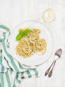 Pasta spaghetti with pesto sauce fresh basil glass of white