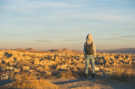 Young woman traveller in hoodie watching sunrise  Cappadocia  Central Turkey