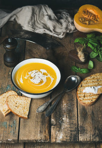 Pumpkin cream soup with fresh basil spices and grilled bread