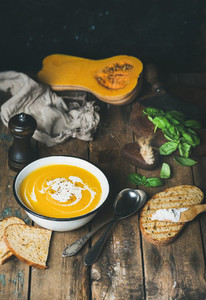 Pumpkin cream soup with fresh green basil spices grilled bread