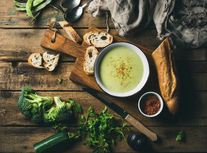 Homemade pea broccoli zucchini cream soup with fresh baguette