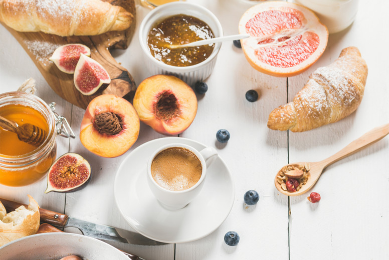 Breakfast snacks and drinks set on white wooden background