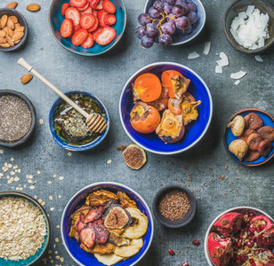 Ingredients for healthy breakfast in bowls over grey stone background