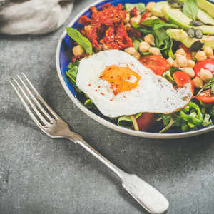 Dieting concept breakfast with fried egg chickpea vegetables seeds