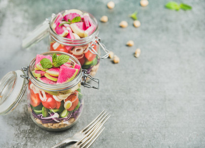 Healthy vegetarian salad in jars with vegetables and chickpea sprouts