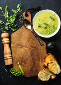 Fresh homemade pea cream soup with bread copy space