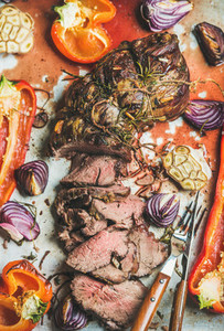 Cooked Roastbeef meat with grilled vegetables and herbs top view